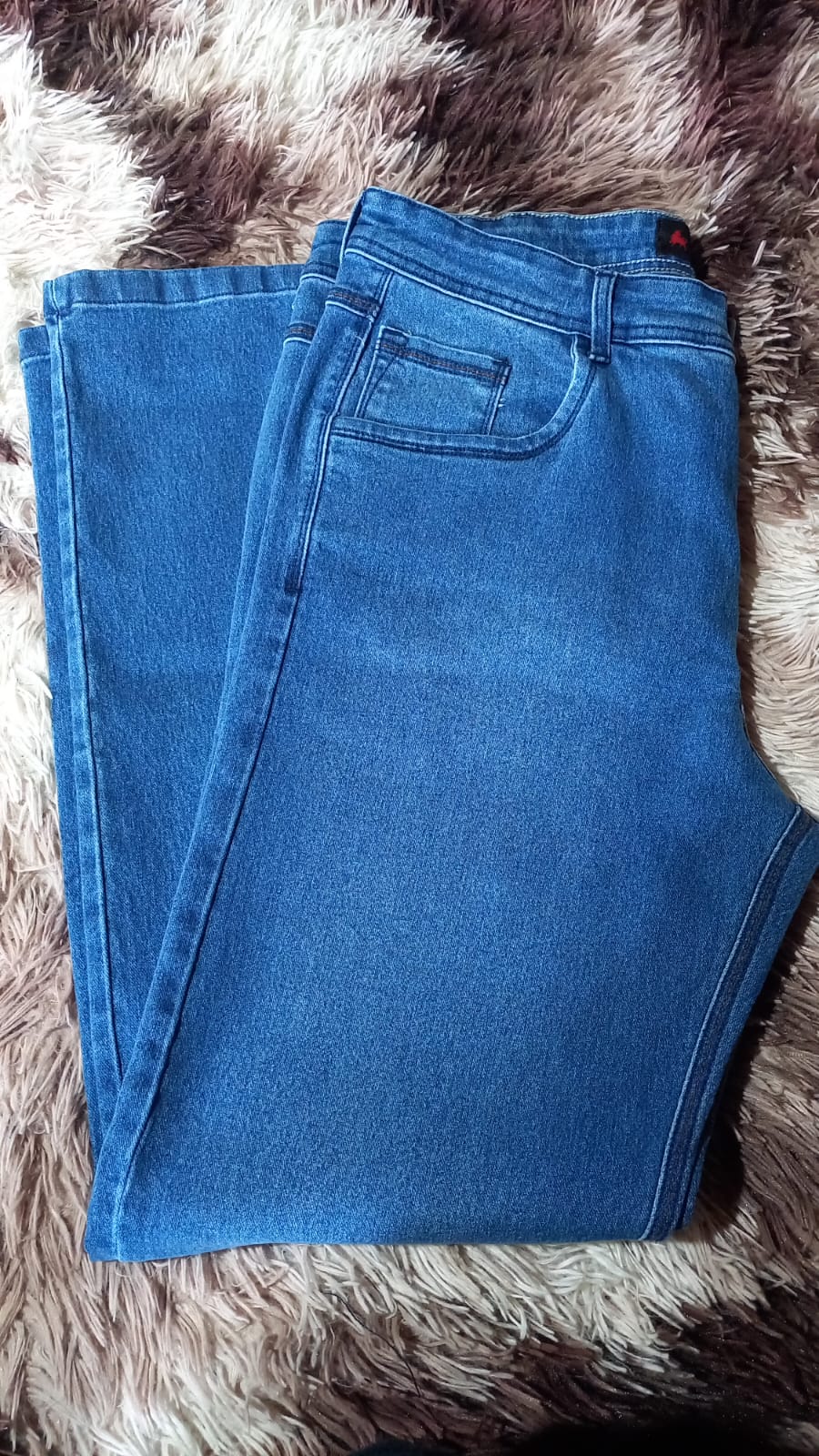 Calça jeans premium Texas Bill girando em vitrine iluminada